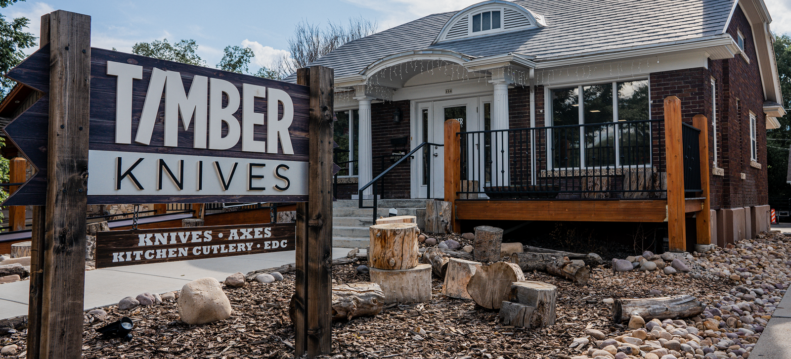 The Timber Knives sign outside the shop on Main Street in Heber City, Utah, with log rounds in the foreground