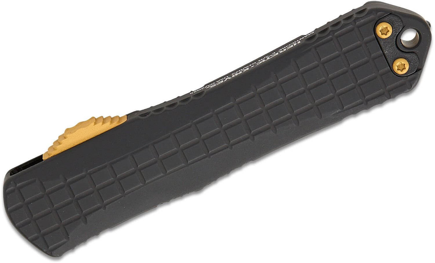 Black grenade grip handle of Heretic Knives Manticore E OTF AUTO Knife with gold accents.